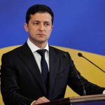 Zelenskyy’s Bold Move: How a Resignation Proposal Could Shift European Security Man in suit speaking at podium with microphones.