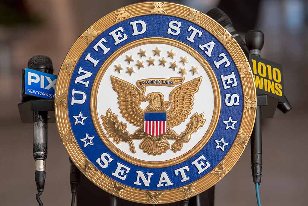 2130082274 featured image US Senate emblem with microphones in background.