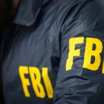 Ex-Olympian Entangled in High-Stakes International Drug Trafficking Scandal Person wearing FBI jacket with yellow lettering