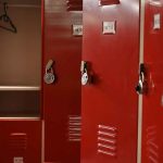 Red lockers with padlocks, one open with hanger.