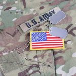 U.S. Army uniform with dog tags and American flag.