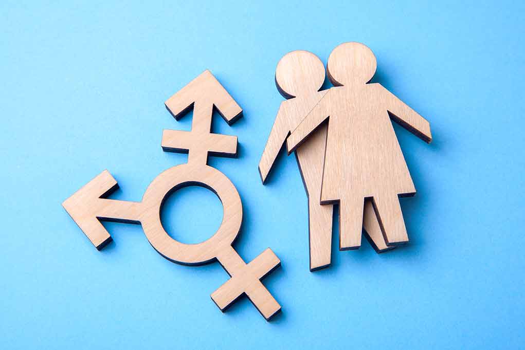 Wooden transgender symbol and couple figures on blue background