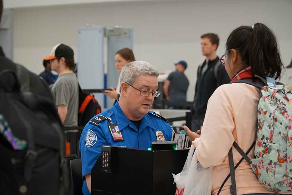 TSA agent checks passenger's documents at airport security
