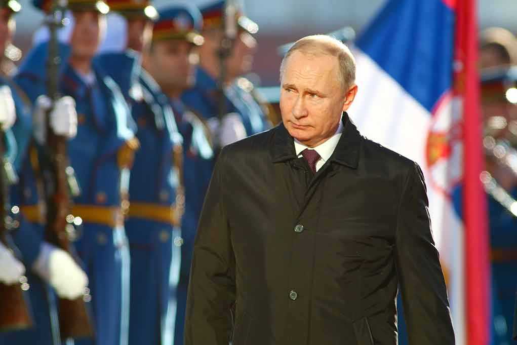 A man in dark coat at a military event