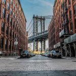 Street view with bridge between two brick buildings