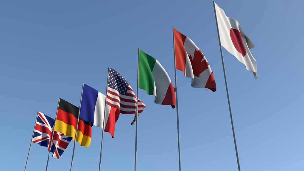 1437085796 Flags of seven countries against clear blue sky