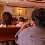 BISHOP Offers Mass Decree to PROTECT Migrants People sitting in church pews during service