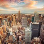 Aerial view of New York City skyline during sunset with skyscrapers and clouds