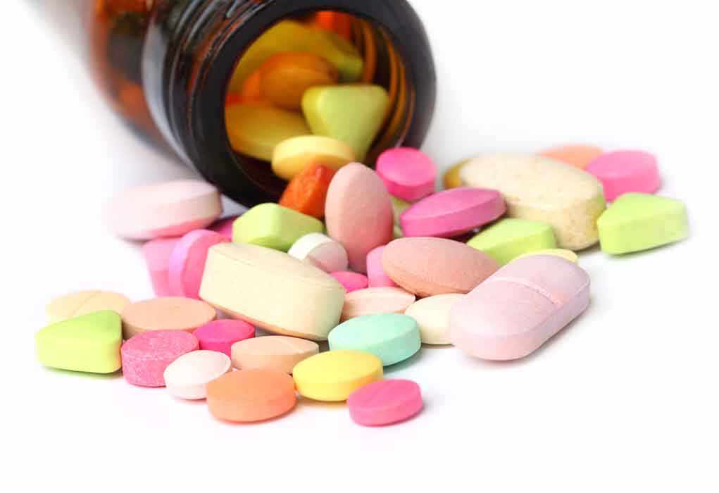 shutterstock_127281623.jpg A variety of colorful pills and tablets spilled from a brown medicine bottle