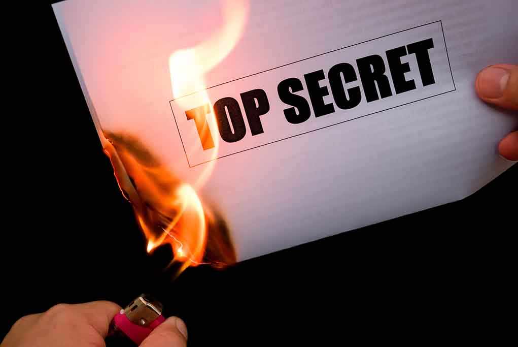 A hand holding a lighter igniting a paper labeled 'TOP SECRET' as it catches fire