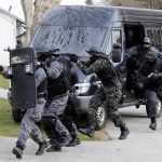 SWAT team members in tactical gear responding to a situation