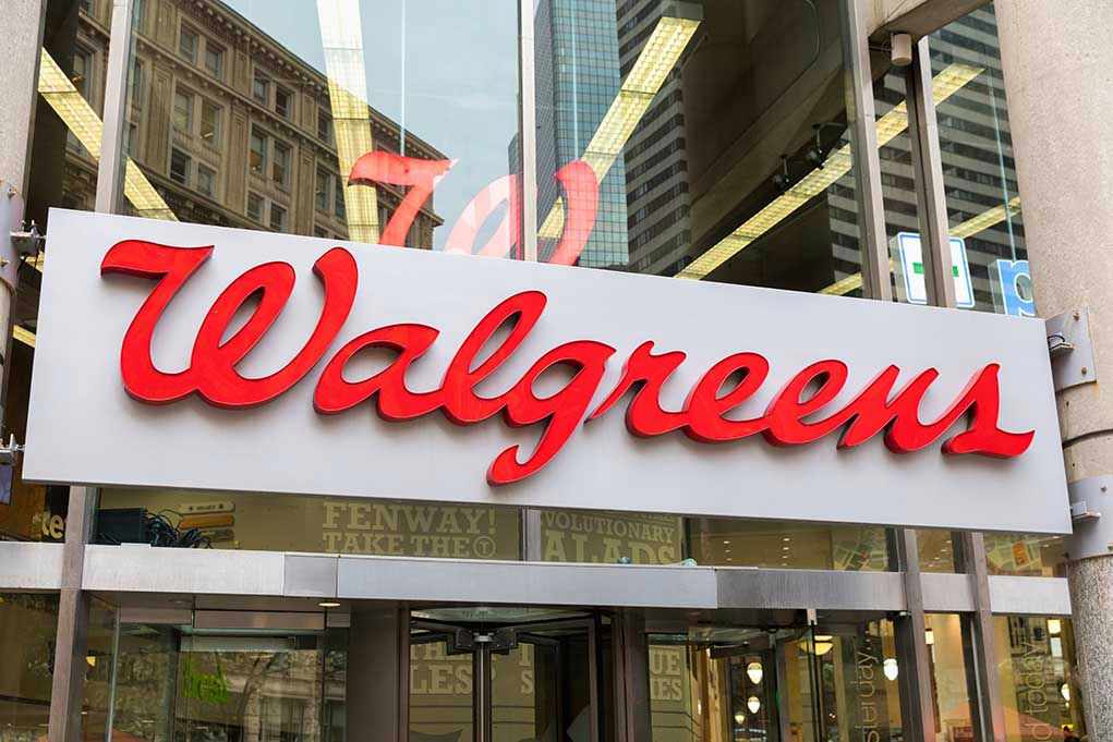 1527898961 Walgreens store entrance sign with city reflections.