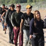 Group of people walking in a line outdoors.