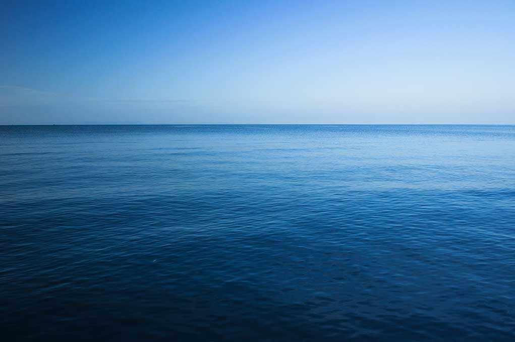 A calm ocean under a clear blue sky