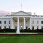 The White House with fountain and American flag.