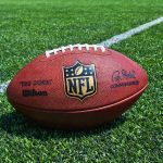 NFL Pro ARRESTED – Dies in Custody! NFL football on a green field.