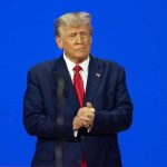 Trump Ally WINS Election – Secures Presidency! Man in a suit with a blue background.