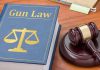 Gun Owners PANIC—Offenders Face Total Ban? Gun Law book and gavel on wooden desk.