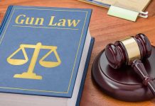 Gun Law book and gavel on wooden desk.