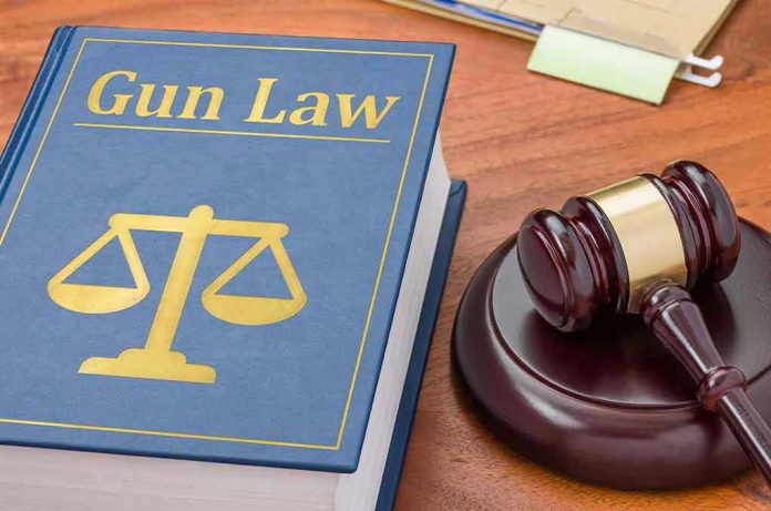 431719843 Gun Law book and gavel on wooden desk.