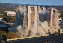 Entire Building COLLAPSES â Hundreds DISPLACED! A building being demolished with dust and debris in the air