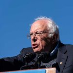 Sanders SLAMS Colleagues Campaign—Party Divided! A speaker passionately addressing a crowd at an outdoor rally