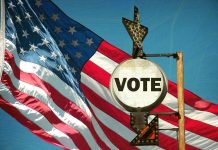 Cuomo Receives MASSIVE Endorsement – Campaign Boost! A vintage Vote sign in front of an American flag