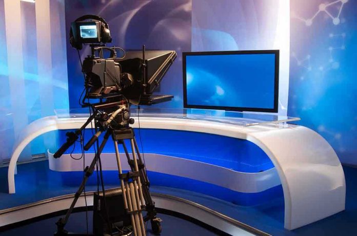 115378765 TV studio with camera and empty anchor desk.