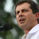 Stunning Accusation: Buttigieg BLASTS Vance! Man speaking into microphone outdoors.