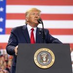 Trump CANCELS Biden Autopen’s – Scandal Unfolds Man speaks at podium with U.S. flag background.