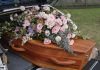 Coffin with flowers in the back of a hearse.