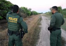 170-mile Police Chase Ends With Border Crossing Two U.S. Border Patrol officers observing a dirt path.