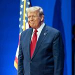 Trump BLINDSIDES – Releases 28 Point Plan Man in suit next to American flag.