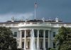 Trump, Mamdani MEET – Tense Opening Exchanges White House with American flag and fountain, stormy sky.