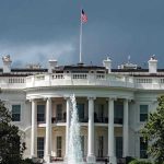 Trump, Mamdani MEET – Tense Opening Exchanges White House with American flag and fountain, stormy sky.