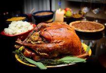 A beautifully roasted turkey on a festive table surrounded by side dishes and decorations
