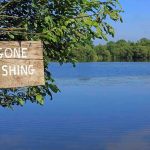 Sign saying Gone Fishing by a lake.