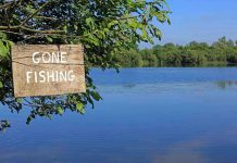 Sign saying Gone Fishing by a lake.