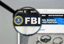 FBI IN TURMOIL: Patel’s Alleged Misuse Of Resources FBI website shown through magnifying glass.