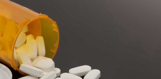 Spilled prescription bottle with white pills.