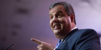 A man in a suit passionately speaking at a podium