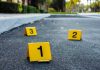 Repeat Offender FREED – Doctor Brutally Attacked! Crime scene markers on asphalt with bullet casing.