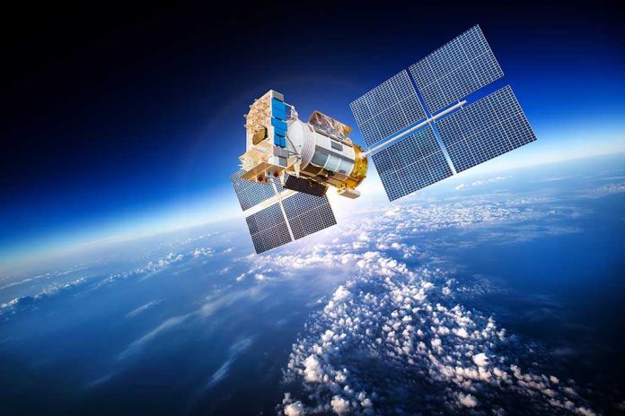 shutterstock_229816288.jpg A satellite equipped with solar panels orbiting above the Earth