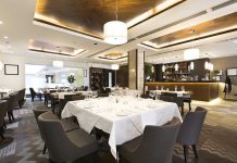 Influencer’s Dine-and-Dash Lands Her in JAIL Interior of a modern restaurant with elegantly set tables and a bar area