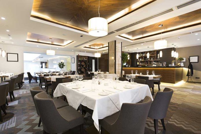 shutterstock_238762006.jpg Interior of a modern restaurant with elegantly set tables and a bar area