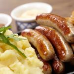 Con Artist Cat Runs Weekly Restaurant Scam Sausages, mashed potatoes, sauerkraut, and sauces on plate.