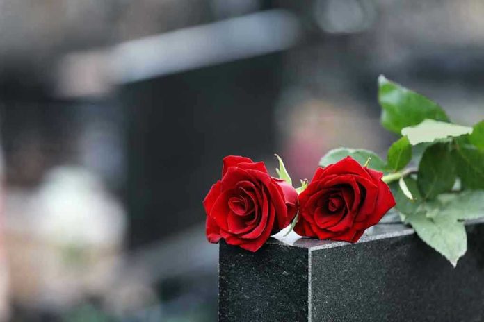 1615218823 Two red roses on a gravestone.