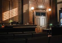 OUTRAGEOUS Bill Protects Rapists From Prison Time Empty courtroom with judges bench and wooden decor.