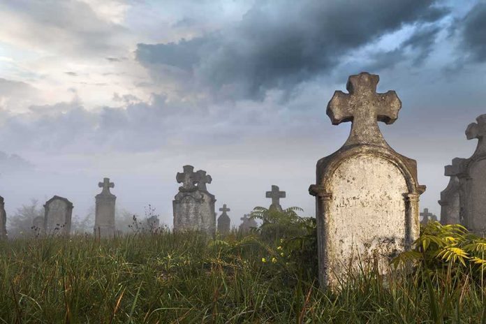 shutterstock_122534365.jpg Foggy graveyard with tombstones and crosses under a cloudy sky