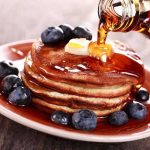 Lawsuit EXPOSES Waffle House’s Dark Secrets Stack of pancakes topped with butter and blueberries, drizzled with maple syrup